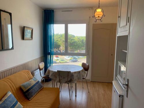 un salon avec une table devant une fenêtre dans l'établissement Le Marina de St Jean de Monts, à Saint-Jean-de-Monts