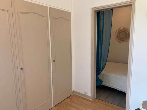 - une chambre avec des placards blancs et un miroir dans l'établissement Le Marina de St Jean de Monts, à Saint-Jean-de-Monts