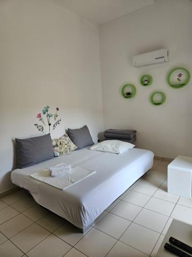 a bedroom with a large white bed with green plates on the wall at Polina Apartmani in Klenovica