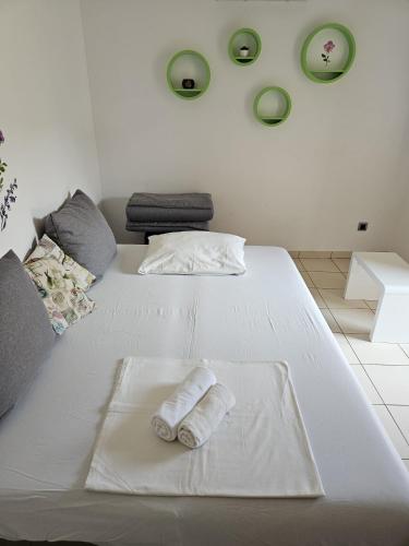 a white bed with two rolled towels on it at Polina Apartmani in Klenovica