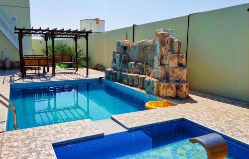 Ţaymissahにあるاستراحة الاصالة alasalahの建物内の滑り台付きスイミングプール