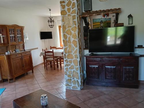 a living room with a flat screen tv on a wooden cabinet at Il gelsomino in Manziana