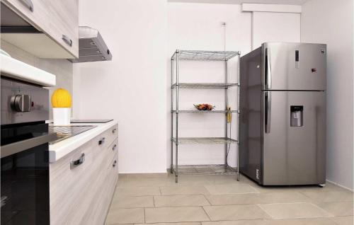 a kitchen with a stainless steel refrigerator and a shelf at 4 Bedroom Cozy Home In Mascalucia in Mascalucia