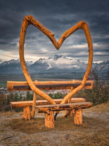 a wooden bench in the shape of a heart at Luxus apartmán pod hradom in Kežmarok