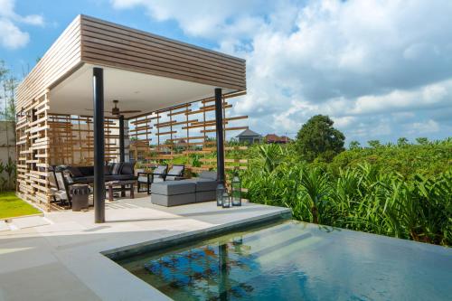 a pavilion with a swimming pool next to a house at Luxury 5BR Canggu Villa with Private Pool, Rice Fields View & Beach Nearby - The Palm House in Canggu