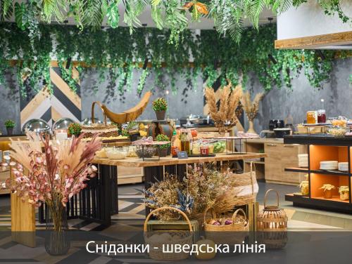 a restaurant with a table filled with food and plants at F&B Spa Resort (ex. Fomich Hotel) in Bukovel