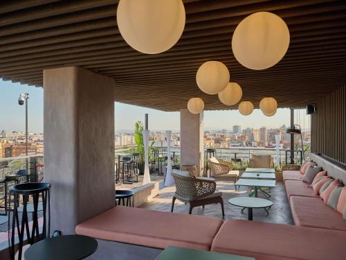 a rooftop patio with tables and chairs and lights at Novotel Valencia Lavant in Valencia