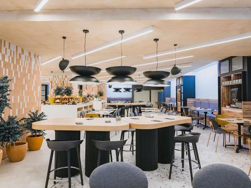 a restaurant with tables and chairs in a room at Novotel Valencia Lavant in Valencia