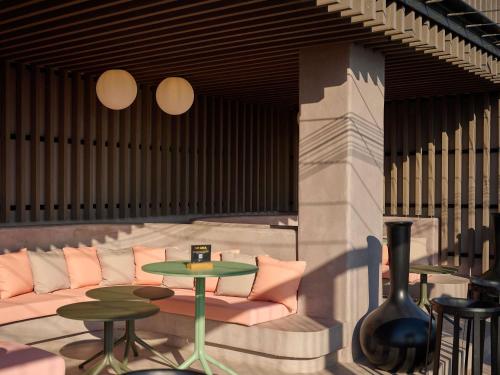 a lobby with a couch and two tables and chairs at Novotel Valencia Lavant in Valencia