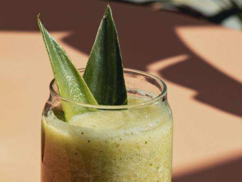a green drink with green leaves in a glass at Novotel Valencia Lavant in Valencia