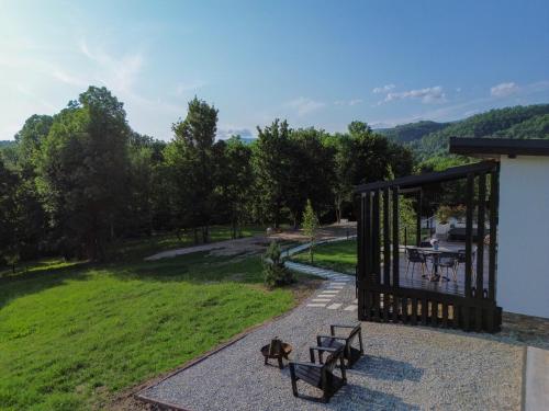 a pavilion with two benches and a table in a field at Transalpina Tiny House - outdoor jacuzzi in Baia de Fier