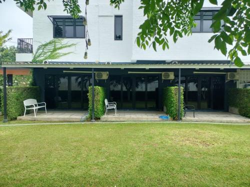 a building with two chairs in front of it at The Modeva Hotel in Kanchanaburi