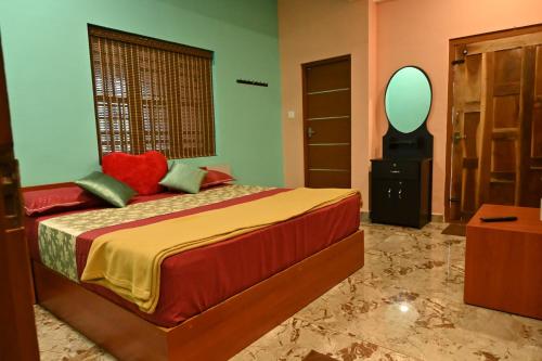 a bedroom with a bed with a mirror on the wall at Brownstones Resort in Kanthalloor