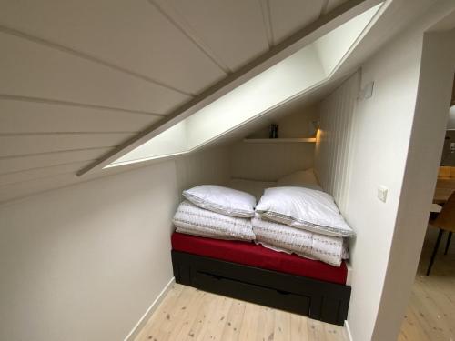 a room with a bed with pillows on it at Holiday home Ejby Ådal in Kirke-Hyllinge