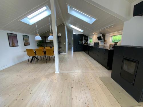 a large room with a wooden floor and a dining room at Holiday home Ejby Ådal in Kirke-Hyllinge