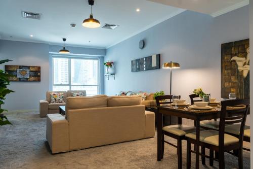 a living room with a couch and a table at Lagom Vacation Homes One Bedroom Apartment Al Shera Tower cluster E in Dubai