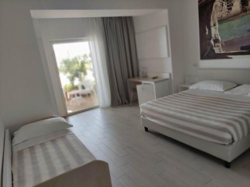 a hotel room with a bed and a window at Est hotel in Santa Cesarea Terme