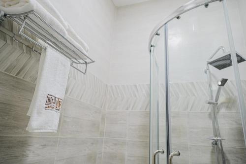 a shower with a glass door in a bathroom at Arkan Al Barzah Hotel Apartment in Sur