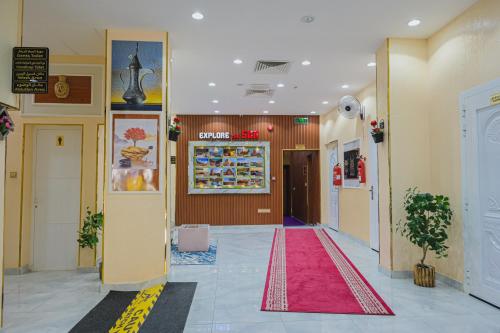 a hallway with a red carpet in a building at Arkan Al Barzah Hotel Apartment in Sur