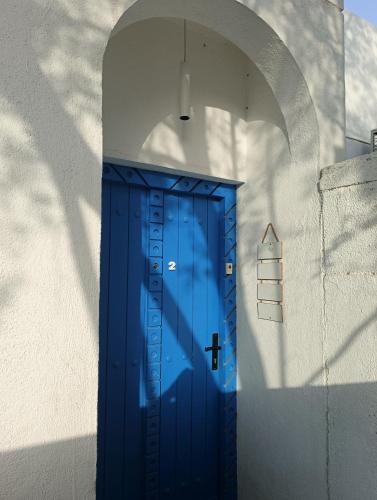 a blue door in a white wall at The Blue Gate 2 in Muscat