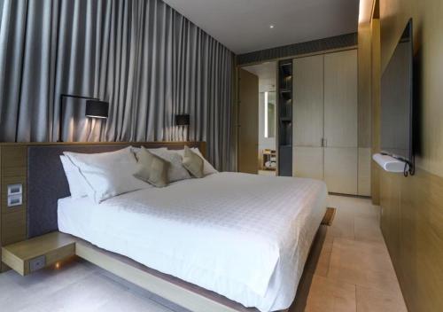 a bedroom with a large white bed in it at JSD Prime Property-Kamala Beach in Surin Beach