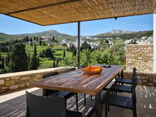 a wooden table on the balcony of a house with a view at Pezoules House II in Lefkes