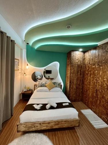 a bedroom with a large bed with a green ceiling at Funtasea Hotel and Beach Resort in Iba