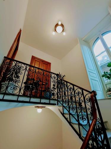 a staircase with a black railing and a window at Lyberty in Randazzo