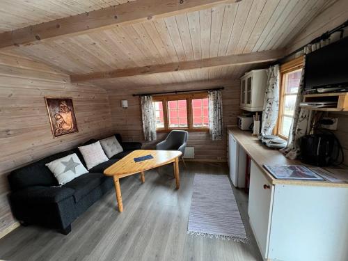 a living room with a couch and a table in a cabin at Nordnes Kro og Camping in Rokland