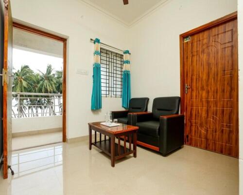 a living room with a chair and a table at Harish Beach Resort in Rāmeswaram
