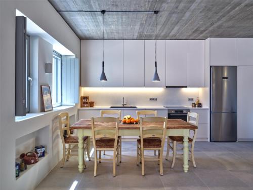 a kitchen with a wooden table and chairs at Pezoules House II in Lefkes