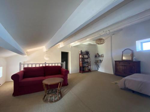 - un salon avec un canapé rouge et un lit dans l'établissement Maison ardéchoise avec panorama, à Sampzon