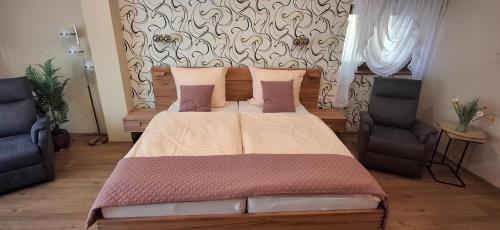 a bedroom with a large bed with two chairs at Alt Wehlheiden in Kassel