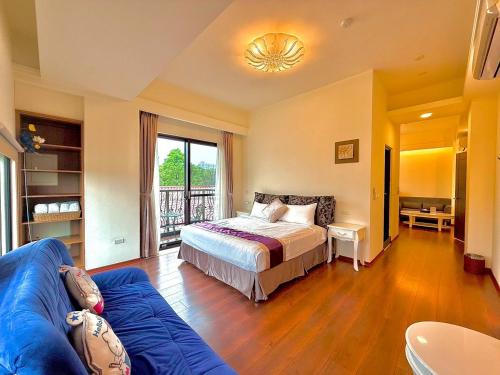 a bedroom with a bed and a blue couch at Kurumba JiJi B&B in Jiji