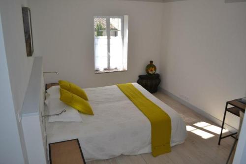 a bedroom with a bed with yellow pillows on it at Appart's Village Trama Loges in Puymirol