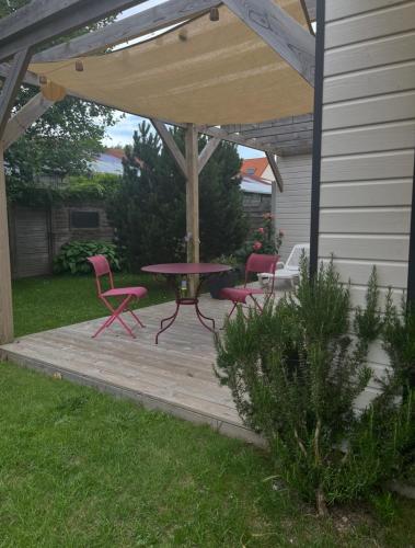 a patio with a table and chairs on a wooden deck at Pavillon d'Éole in Berck-sur-Mer