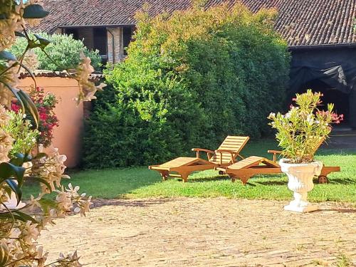 a garden with two chairs and a bench and a bush at Borgo dei Duchi in Rivarolo Mantovano