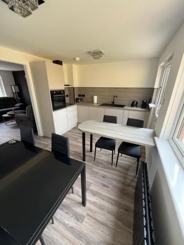 a kitchen and living room with a table and chairs at Home Comfort Prestwick in Prestwick