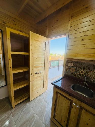 a kitchen with wooden cabinets and a sink and a window at Dalida House in Dahab