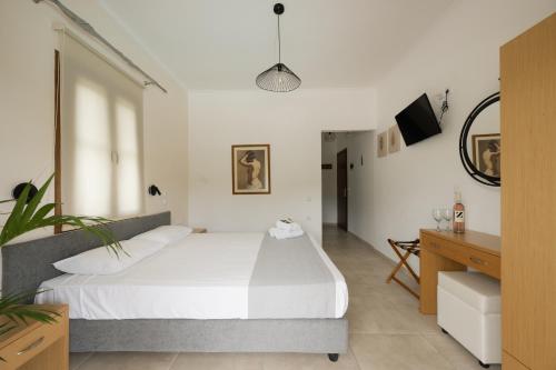 a bedroom with a large white bed and a desk at Villa Apollo in Parga