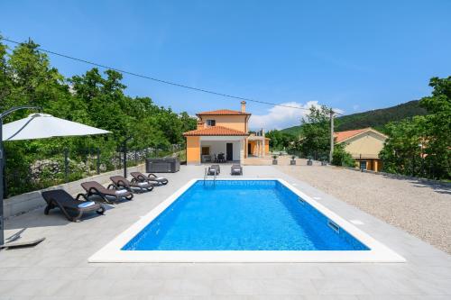 a swimming pool with chairs and a house at Villa Laura by Briskva in Ripenda Kras