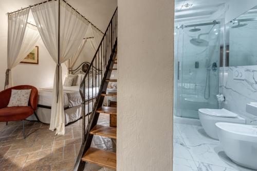 a bathroom with a spiral staircase leading to a bedroom at PALAZZO DEL CAPITANO Wellness & Relais - Luxury Borgo Capitano Collection in San Quirico dʼOrcia