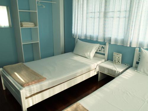 a small bedroom with two beds and a window at Makmai Villa - Rayong in Ban Phe