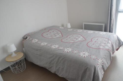 - un lit avec une couverture et des cœurs dans l'établissement L'escale phare, à La Rochelle