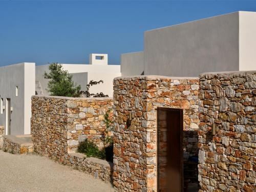 a stone wall with a door in front of a building at Pezoules House II in Lefkes