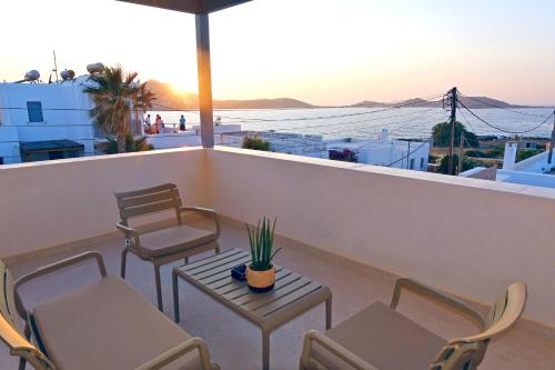 a balcony with chairs and a table with a plant on it at La Maltese Central in Naousa