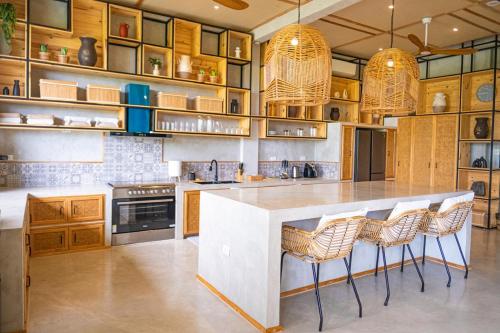 a kitchen with a large island with bar stools at Ricehaven Luxury Villa with Starlink WIFI Villa2 in General Luna
