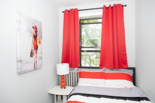 a bedroom with red curtains and a bed with a window at Ruby Room at Brighton Beach 2-Min Walk to Ocean & Subway Chic Stay in Brooklyn