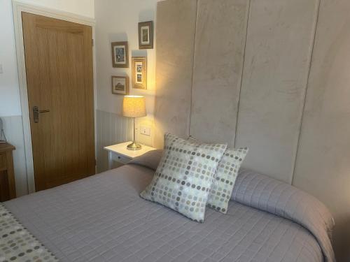a bedroom with a bed with two pillows and a lamp at Morgraig in Cardiff
