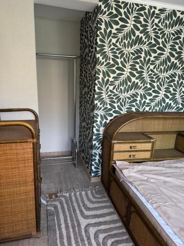 a bedroom with a bed and a patterned wall at Sunny Nest in Odesa